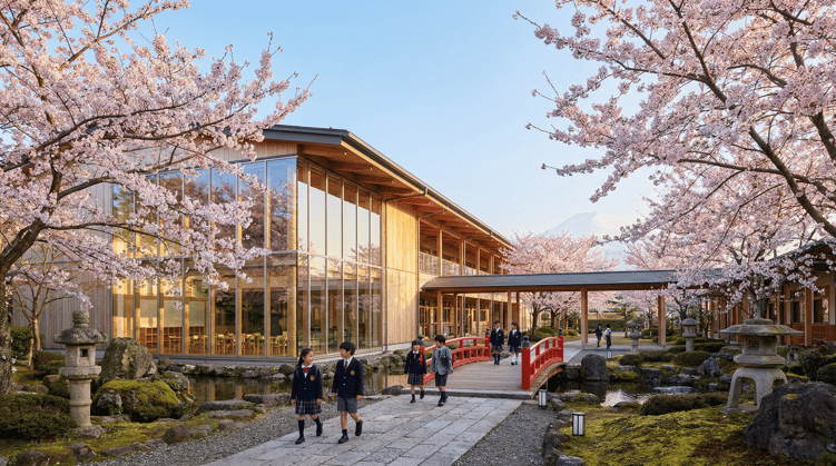 Affordable international school campus in Japan surrounded by cherry blossom trees with Mount Fuji in the background